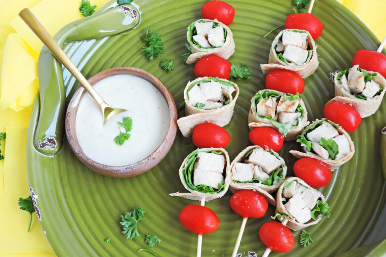 Mini Chicken Caesar Salad on a wooden skewer with cherry tomatoes