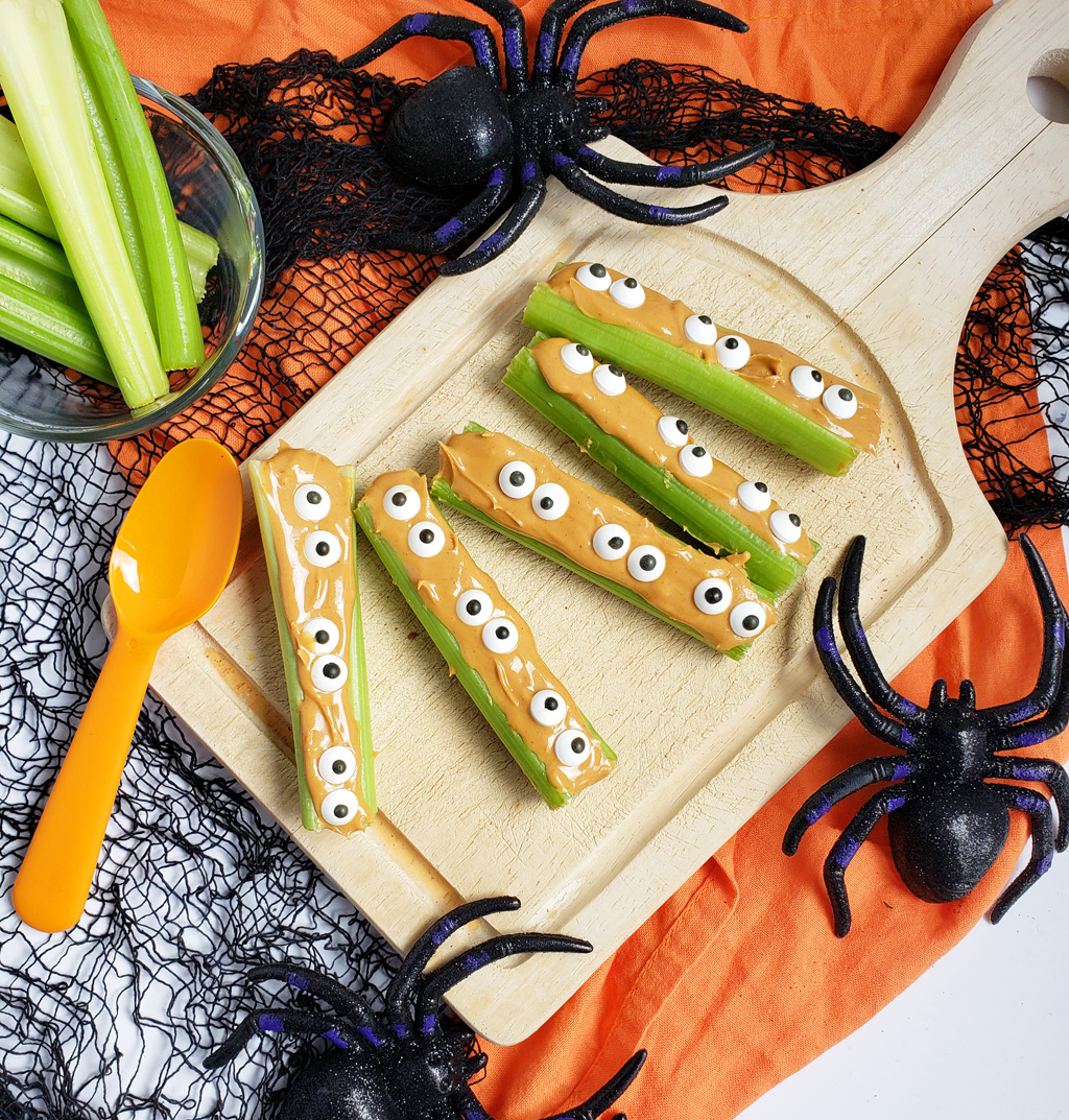 spooky monsters on a log made with celery sticks, peanut butter and candy eyes