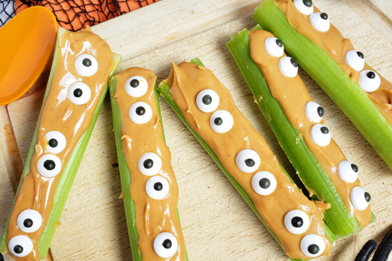 spooky monsters on a log made with celery sticks, peanut butter and candy eyes