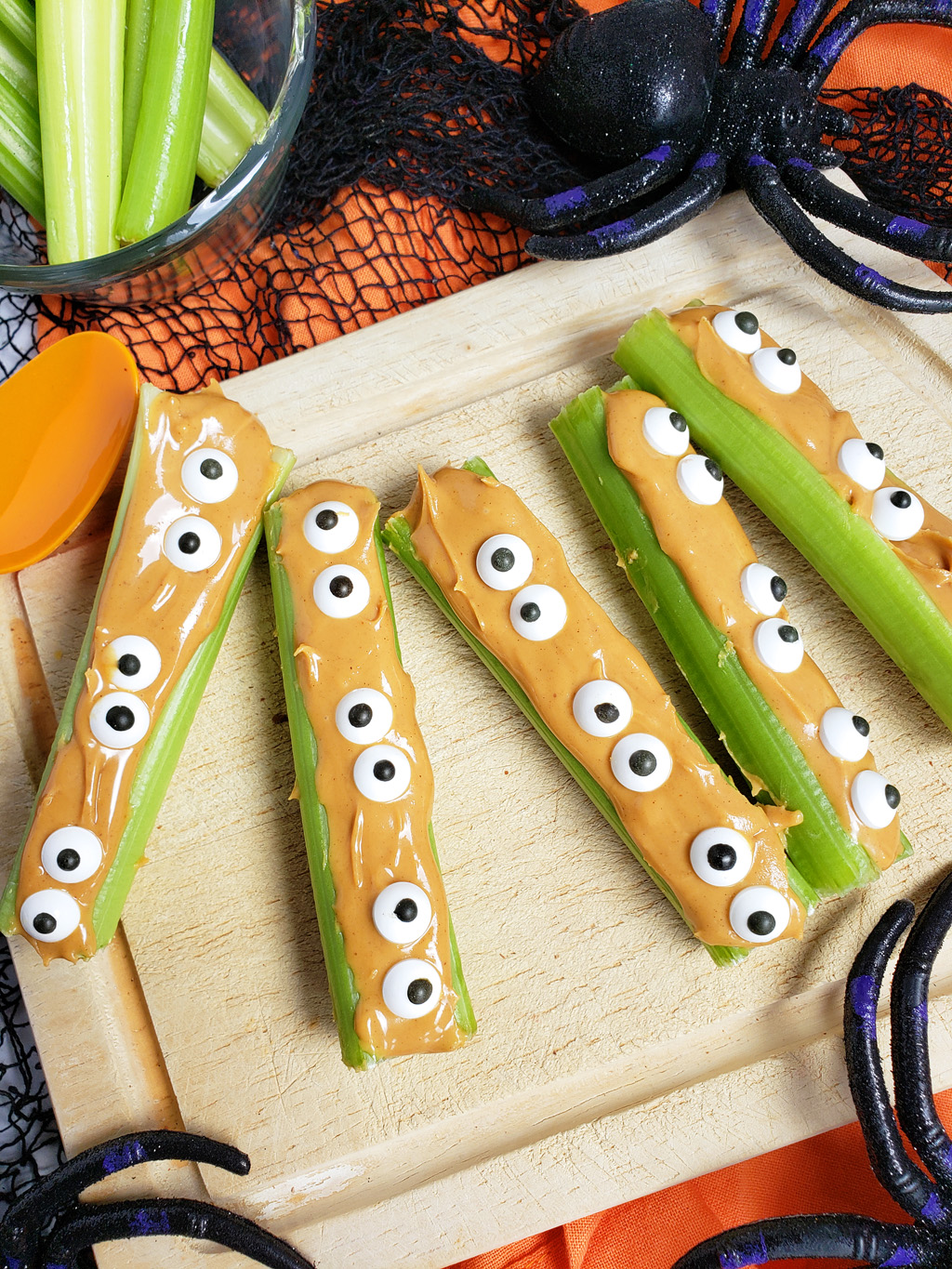 spooky monsters on a log made with celery sticks, peanut butter and candy eyes