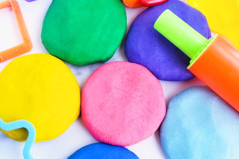 Easy No-Cook DIY Playdough, made with no cream of tartar, and no cooking required. The easiest playdough recipe ever. Different color playdough and utensils. #sensoryactivities #indooractivitiesforkids #indooractivities #homemadeplaydough #playdoh