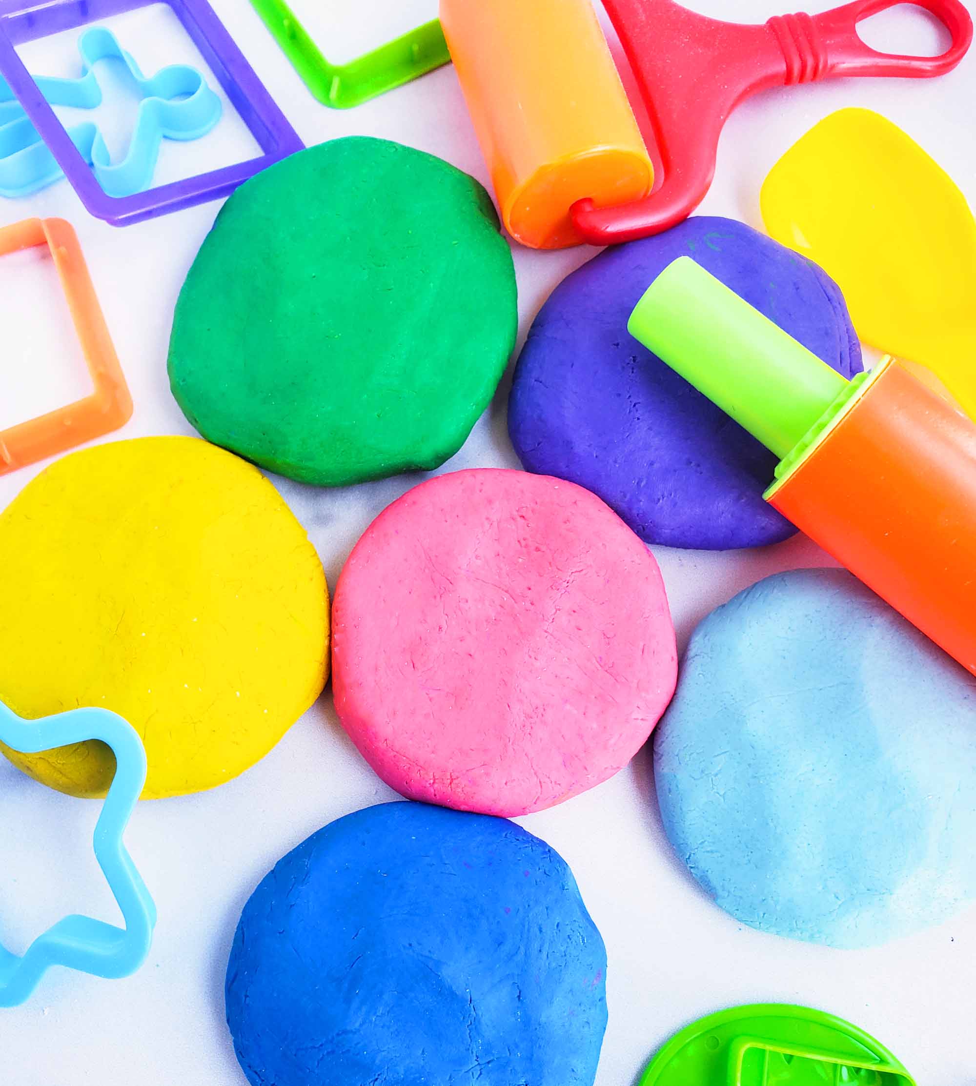 Easy No-Cook DIY Playdough, made with no cream of tartar, and no cooking required. The easiest playdough recipe ever. Different color playdough and utensils. #sensoryactivities #indooractivitiesforkids #indooractivities #homemadeplaydough #playdoh