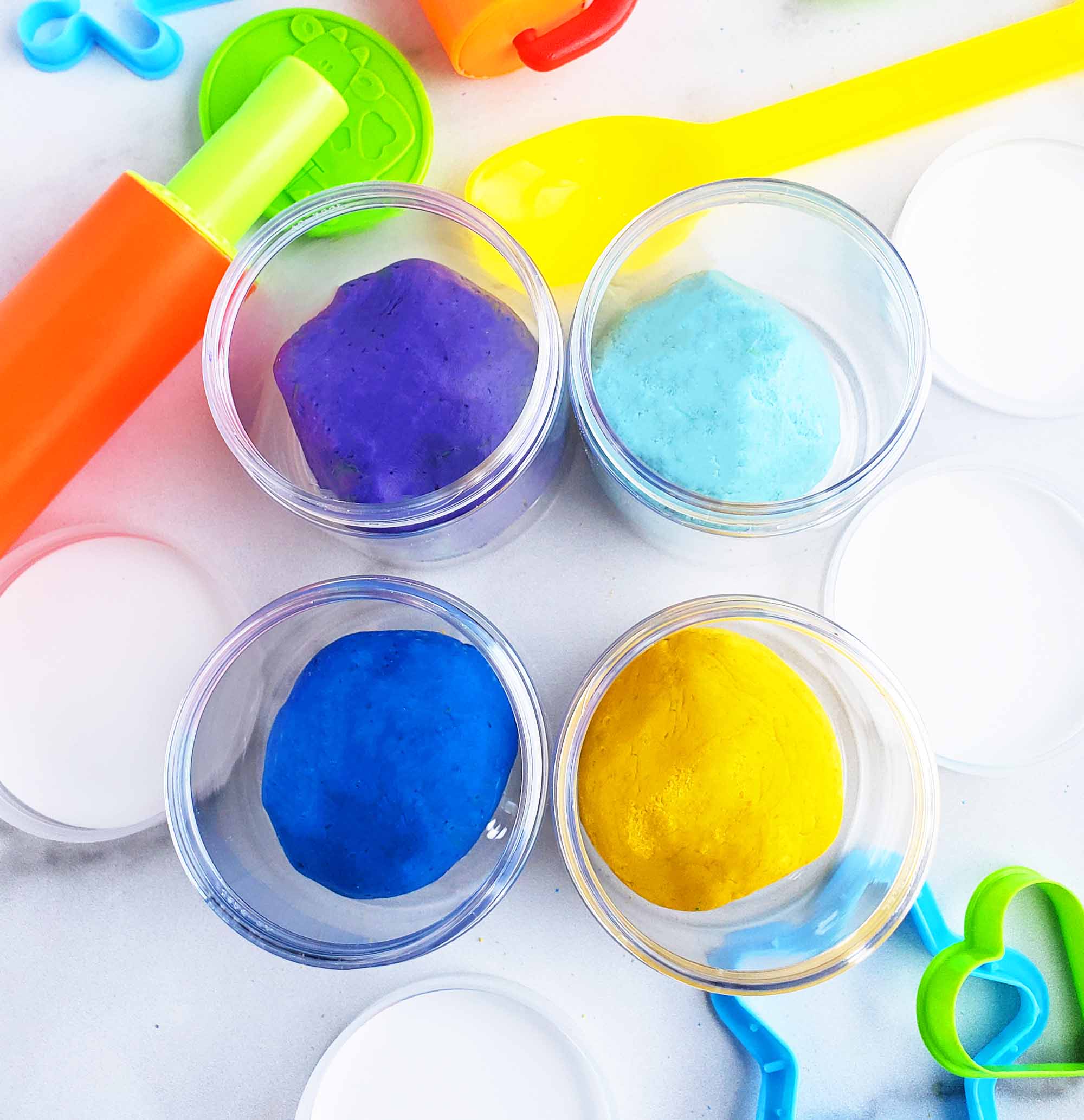 Easy No-Cook DIY Playdough, made with no cream of tartar, and no cooking required. The easiest playdough recipe ever. Different color playdough and utensils. #sensoryactivities #indooractivitiesforkids #indooractivities #homemadeplaydough #playdoh