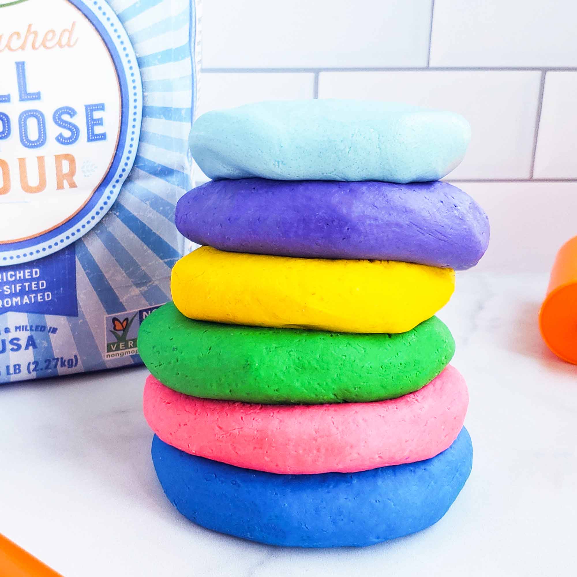 Easy No-Cook DIY Playdough, made with no cream of tartar, and no cooking required. The easiest playdough recipe ever. Different color playdough and utensils. #sensoryactivities #indooractivitiesforkids #indooractivities #homemadeplaydough #playdoh