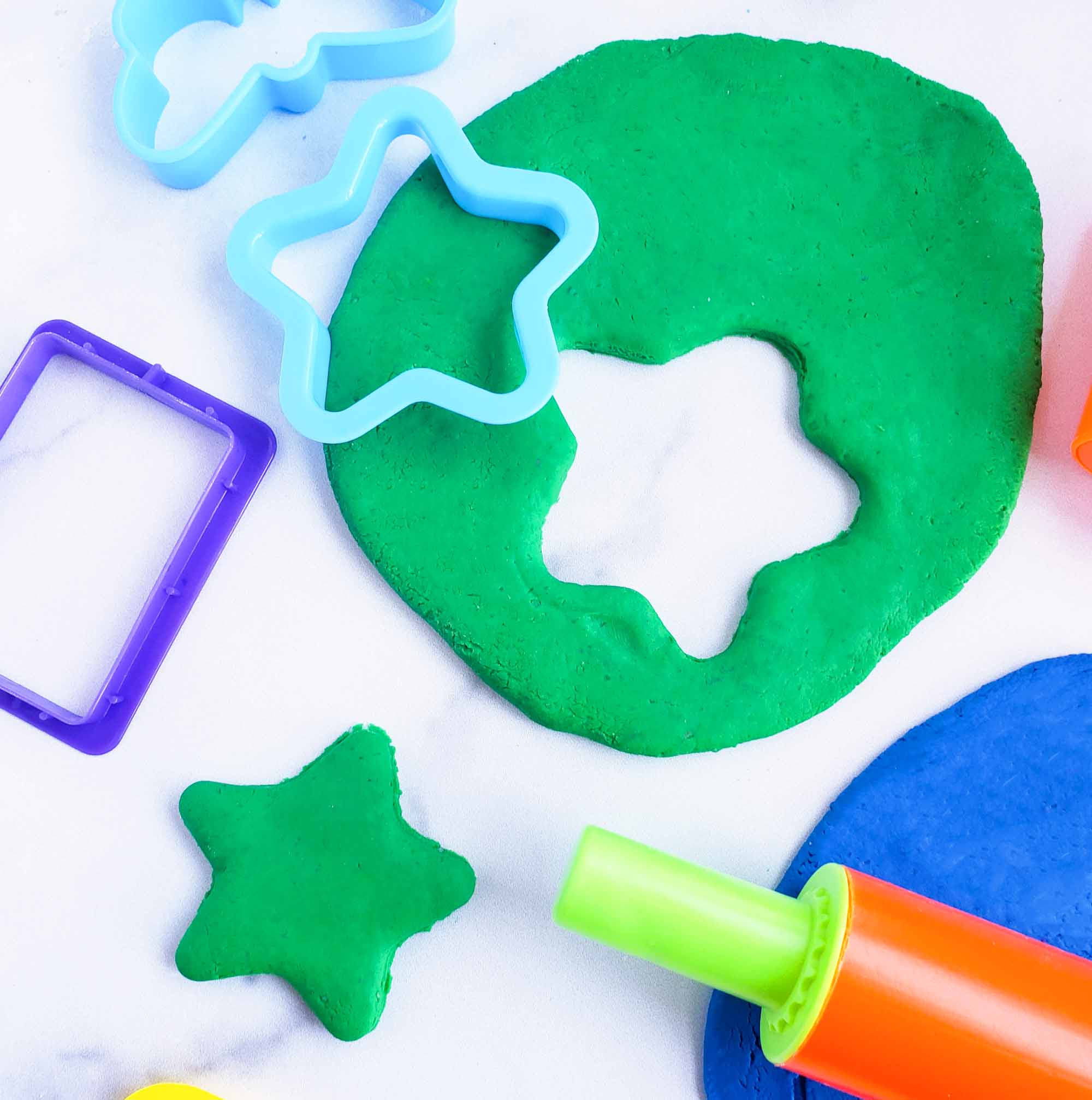 Easy No-Cook DIY Playdough, made with no cream of tartar, and no cooking required. The easiest playdough recipe ever. Different color playdough and utensils. #sensoryactivities #indooractivitiesforkids #indooractivities #homemadeplaydough #playdoh