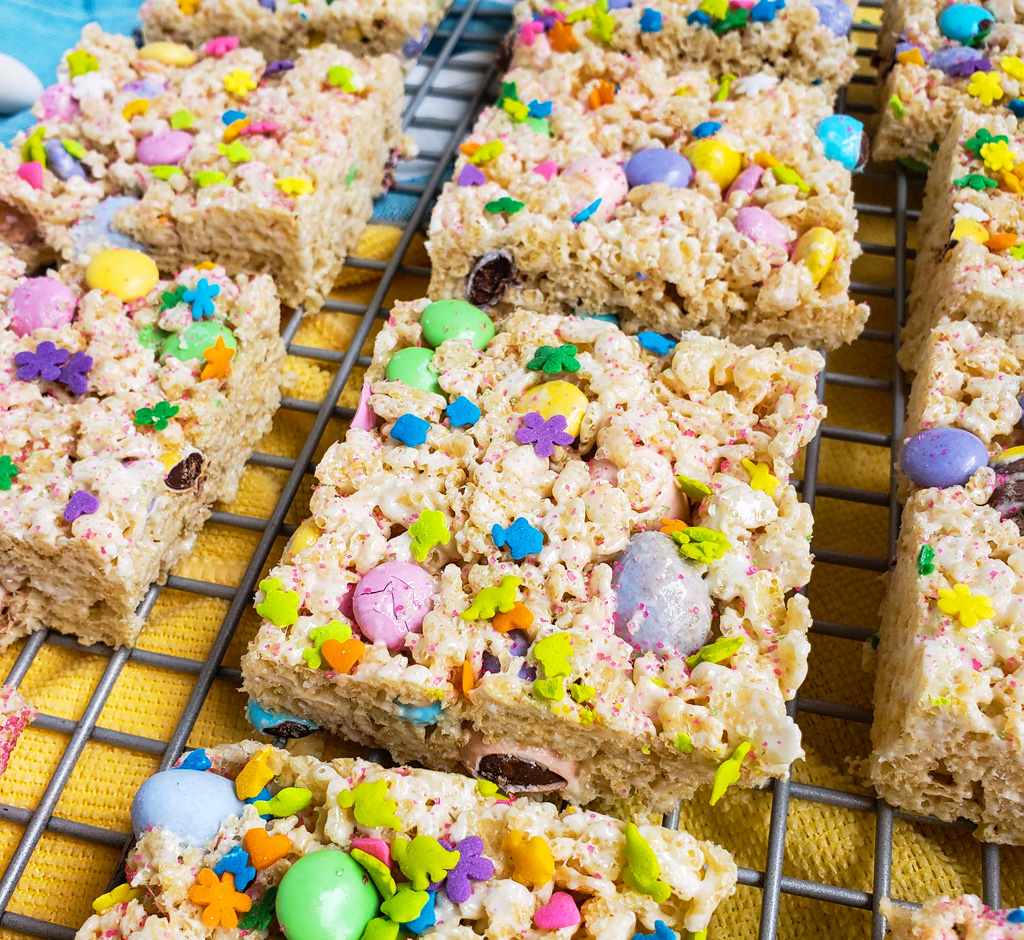 The Best Easter Rice Krispies Treats made with M&Ms, Cadbury eggs, and sprinkles. Cut into squares on a wire rack. The perfect Spring treat