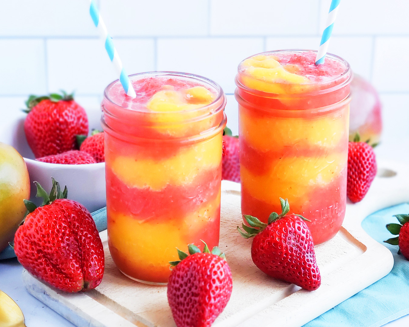 Fresh Mango Strawberry Swirled Slushies. Summer is almost here, so let’s celebrate with these Fresh Mango Strawberry Swirled Slushies, made with fresh mangos (mangoes) and strawberries, and sweetened with a touch of honey. #slush #slushies #fruitslushies #frozentreats #healthytreatsforkids #kidapproved littleeatsandthings.com