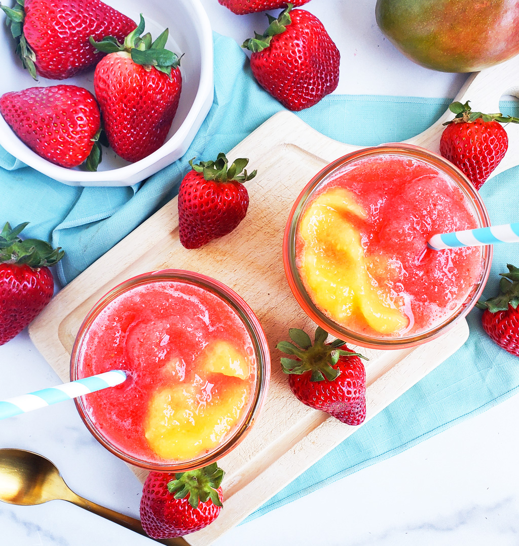 Fresh Mango Strawberry Swirled Slushies. Summer is almost here, so let’s celebrate with these Fresh Mango Strawberry Swirled Slushies, made with fresh mangos (mangoes) and strawberries, and sweetened with a touch of honey. #slush #slushies #fruitslushies #frozentreats #healthytreatsforkids #kidapproved littleeatsandthings.com