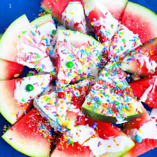 Fun & Easy Sweet Watermelon Nachos made with vanilla Greek yogurt, honey, and sprinkles. The perfect summer treat, also great for the 4th of July. Littleeatsandthings.com