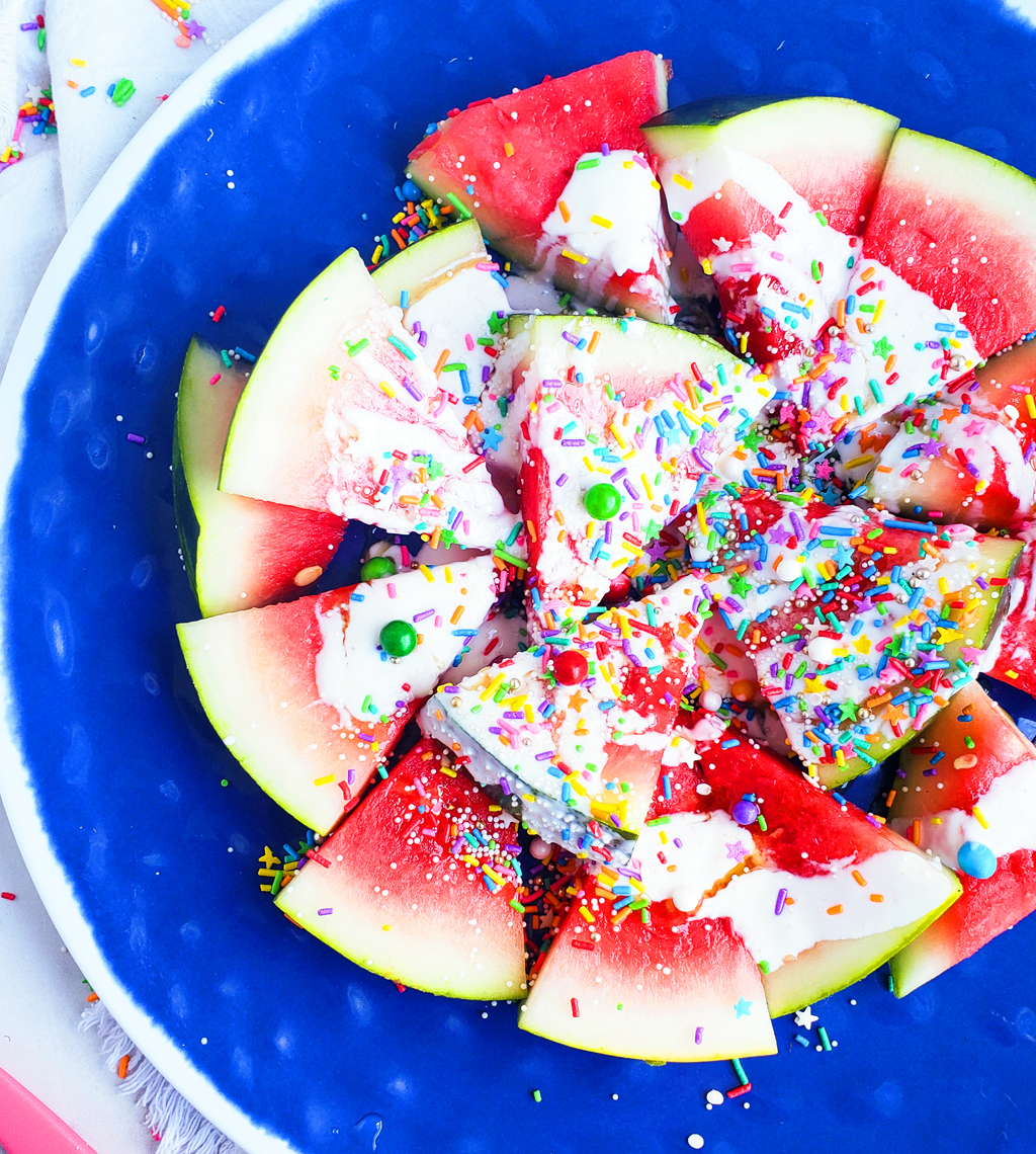 Fun & Easy Sweet Watermelon Nachos made with vanilla Greek yogurt, honey, and sprinkles. The perfect summer treat, also great for the 4th of July. Littleeatsandthings.com