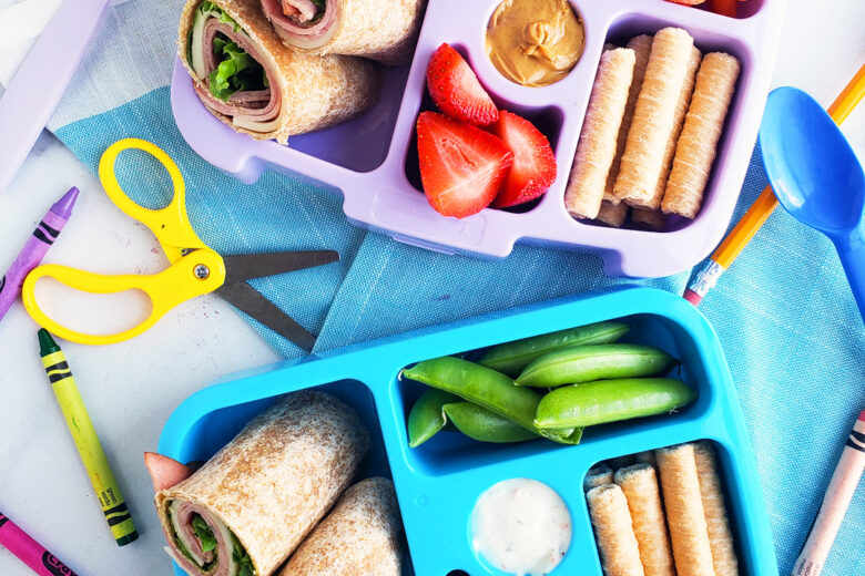 Bento box filled and arranged beautifully with fruits, veggies, whole wheat ham and cheese wraps. Healthy bento lunch ideas for kids. Littleeatsandthings.com