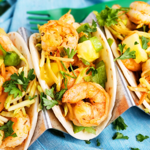 These Spicy Jerk Shrimp Mini Tacos are loaded with so much flavor and super easy to make! These street tacos are piled high with marinated slaw, jerk shrimp, pineapple, and green onions. Littleeatsandthings.com