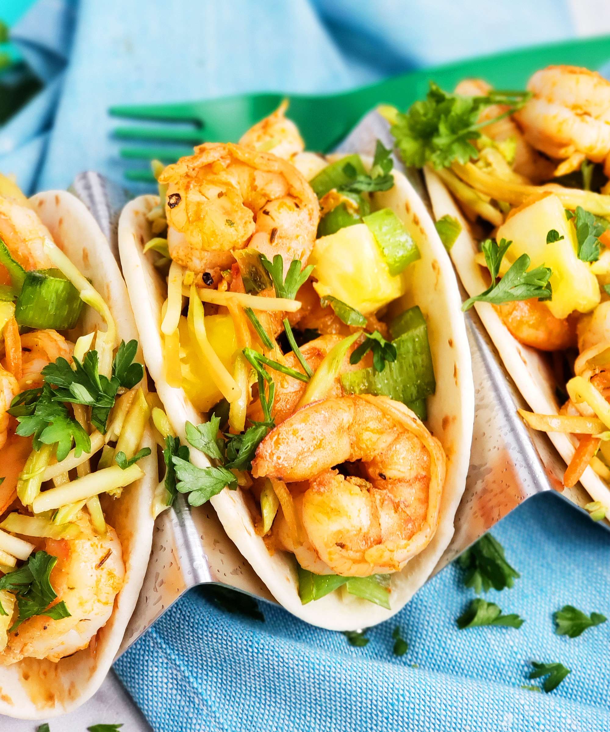 These Spicy Jerk Shrimp Mini Tacos are loaded with so much flavor and super easy to make! These street tacos are piled high with marinated slaw, jerk shrimp, pineapple, and green onions. Littleeatsandthings.com