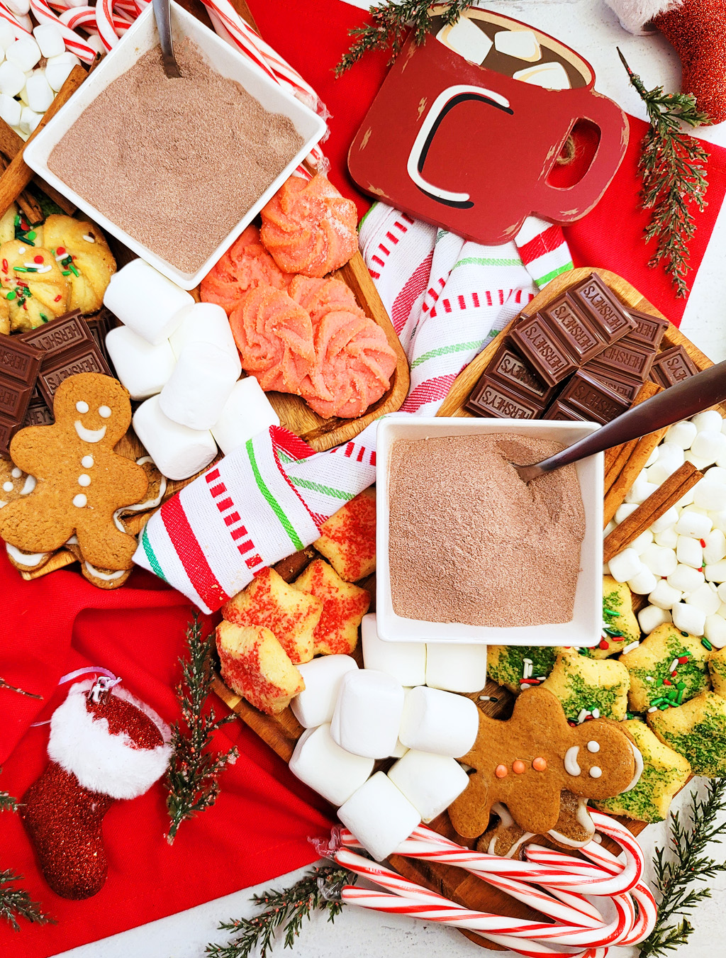 DIY Holiday Hot Cocoa Charcuterie Board on a wooden cutting board with gingerbread cookies, marshmallows, and hot chocolate mix. The perfect Christmas charcuterie board. www.littleeatsandthings.com 