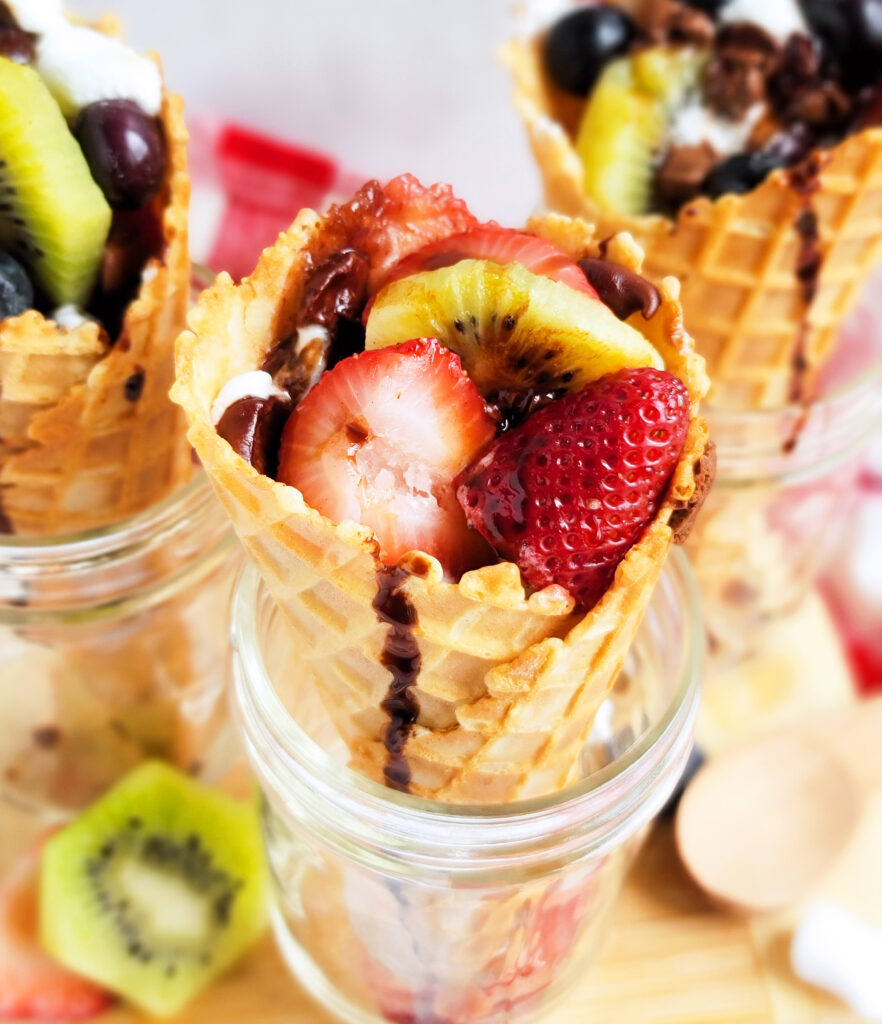 fire up the grill and make these delicious Fruity Campfire Cones made with waffle cones stuffed with marshmallows, chocolate chips, strawberry, kiwi, and blueberries littleeatsandthings.com