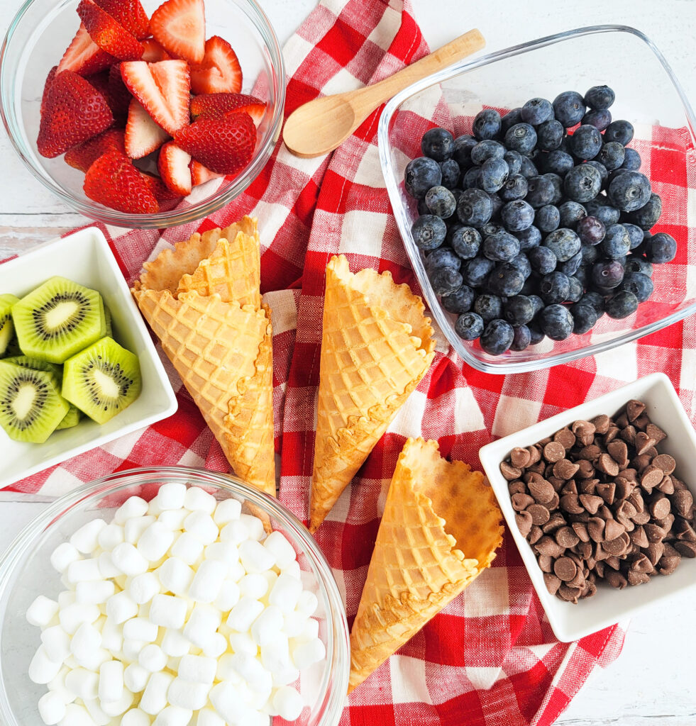 fire up the grill and make these delicious Fruity Campfire Cones made with waffle cones stuffed with marshmallows, chocolate chips, strawberry, kiwi, and blueberries littleeatsandthings.com