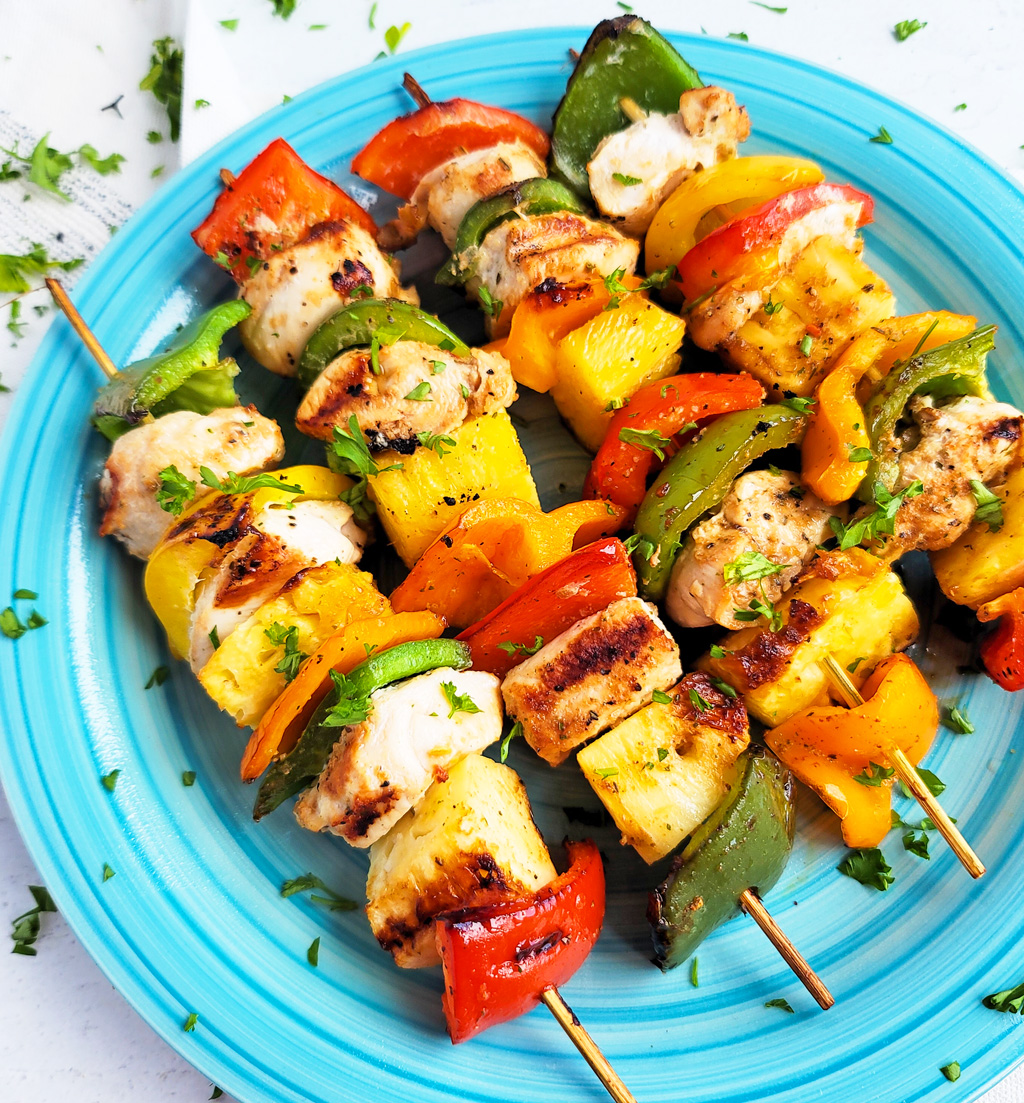 Make this Memorial Day weekend the best one yet with these super fun Hawaiian Grilled Chicken & Pineapple Kabobs made with red bell peppers, green bell peppers, yellow bell peppers and orange bell peppers, pineapples, and chicken. littleeatsandthings.com