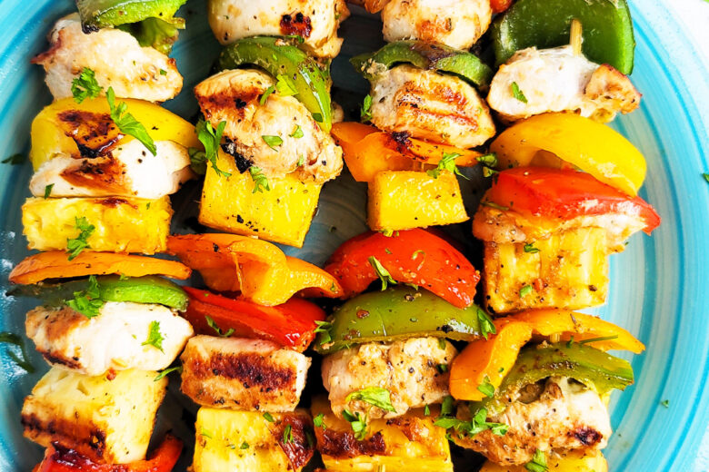 Make this Memorial Day weekend the best one yet with these super fun Hawaiian Grilled Chicken & Pineapple Kabobs made with red bell peppers, green bell peppers, yellow bell peppers and orange bell peppers, pineapples, and chicken. littleeatsandthings.com