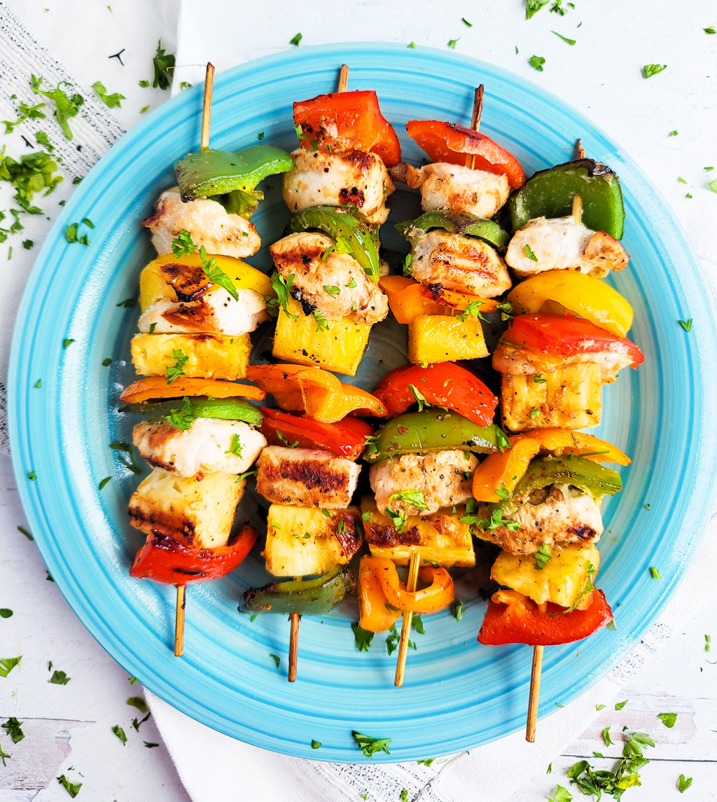 Make this Memorial Day weekend the best one yet with these super fun Hawaiian Grilled Chicken & Pineapple Kabobs made with red bell peppers, green bell peppers, yellow bell peppers and orange bell peppers, pineapples, and chicken. littleeatsandthings.com