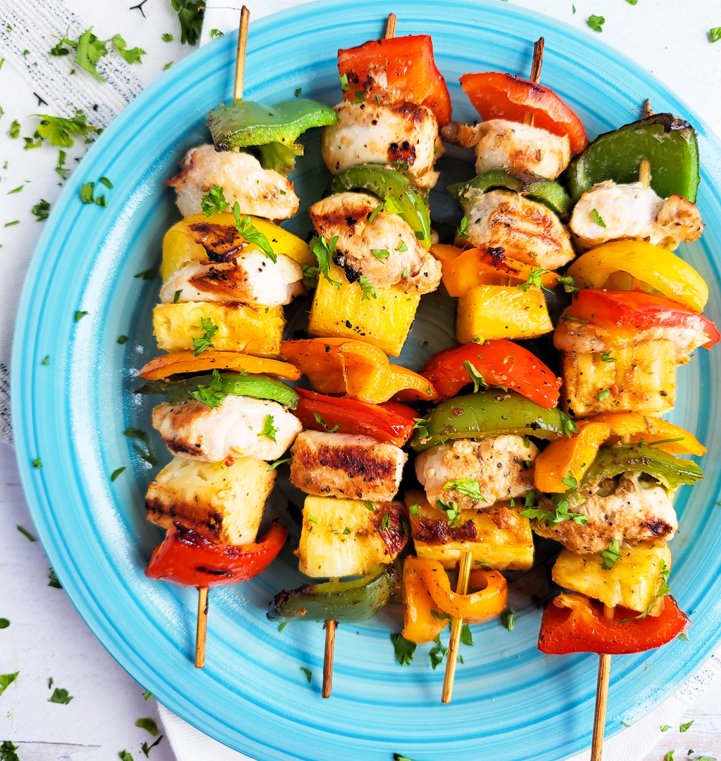 Make this Memorial Day weekend the best one yet with these super fun Hawaiian Grilled Chicken & Pineapple Kabobs made with red bell peppers, green bell peppers, yellow bell peppers and orange bell peppers, pineapples, and chicken. littleeatsandthings.com