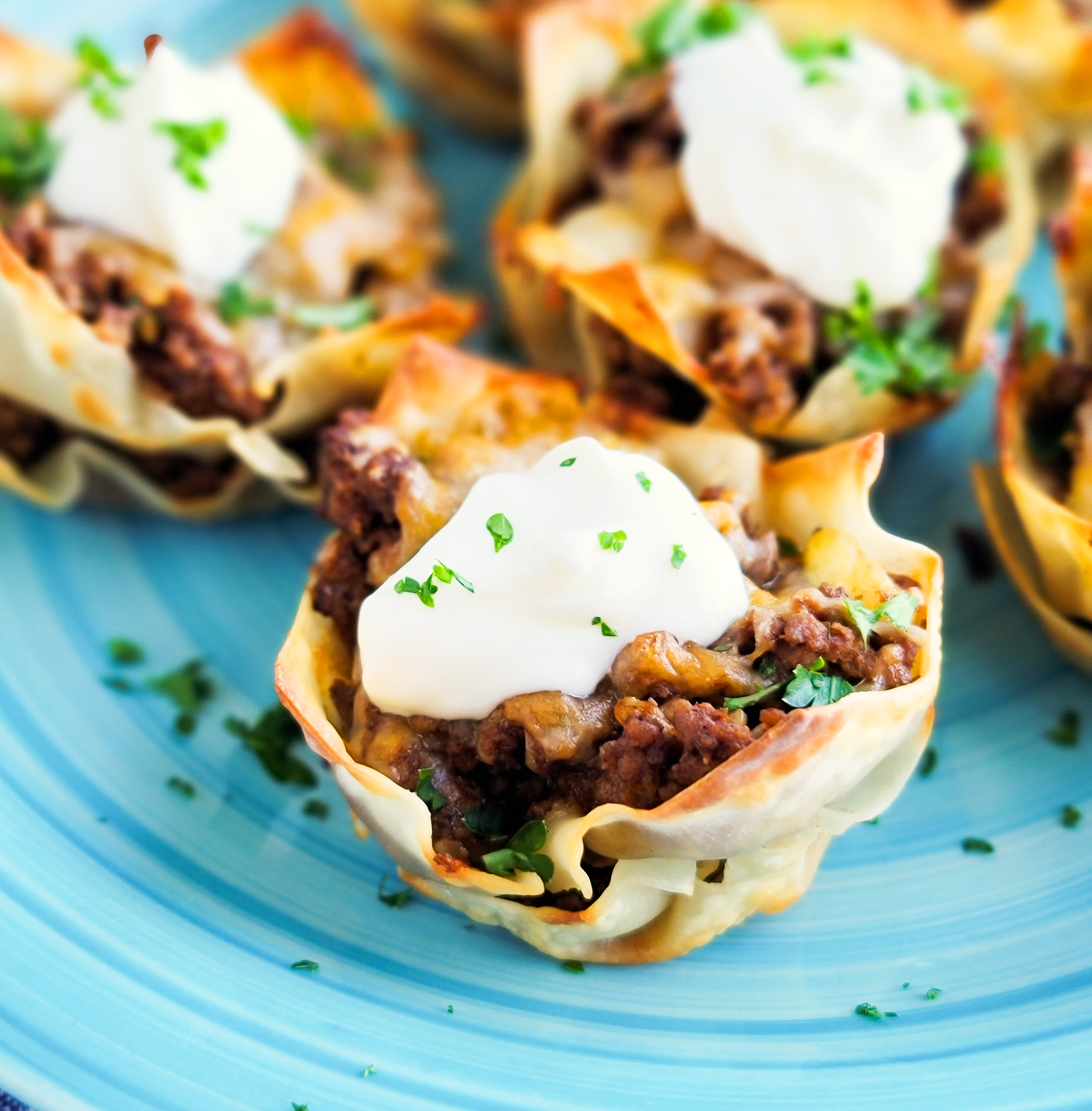 Easy Cheesy Taco Cups! Perfect for Taco Tuesday made with wontons, taco meat, sour cream.  beautifuleatsandthings.com