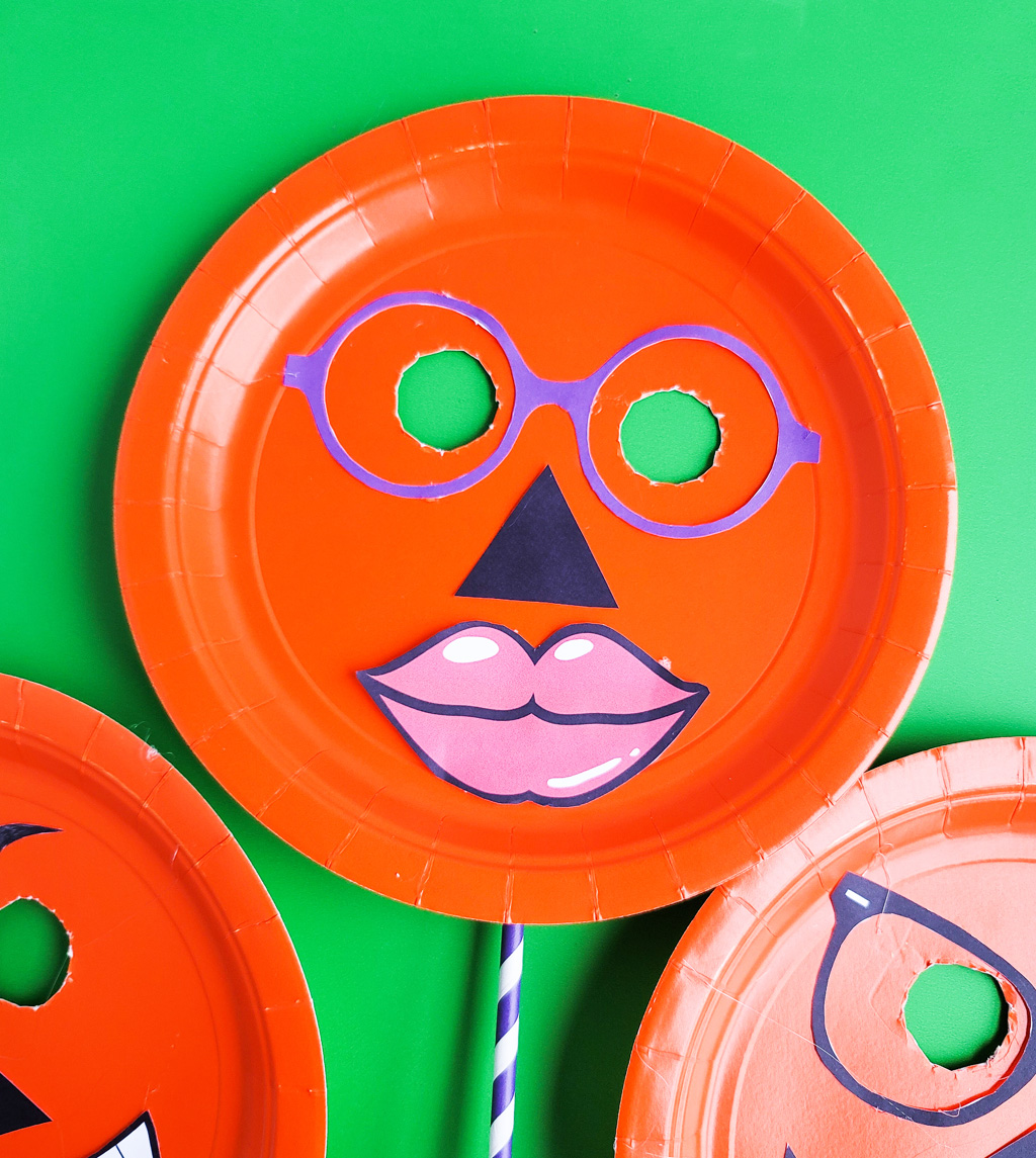 DIY Halloween Pumpkin Masks made with orange Paper Plates and cut out faces littleeatsandthings.com