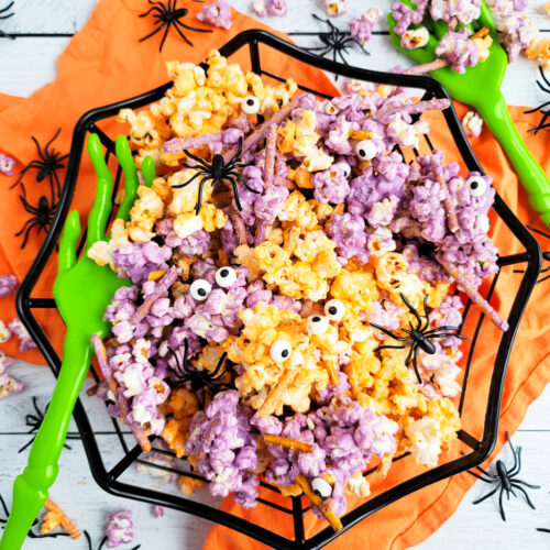 Spooky Halloween Popcorn Mix for the kids made with purple and orange white chocolate, pretzels, and candy eyeballs with black plastic spiders. beautifuleatsandthings.com