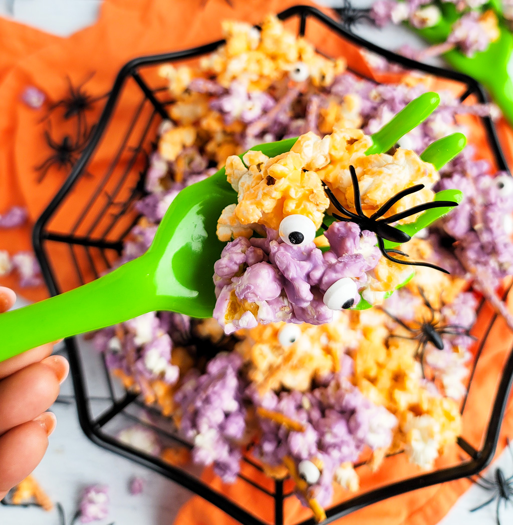 Spooky Halloween Popcorn Mix for the kids made with purple and orange white chocolate, pretzels, and candy eyeballs with black plastic spiders. beautifuleatsandthings.com