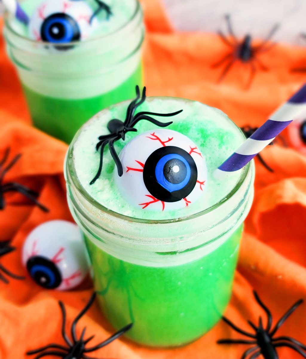 Try this Spooky Green Halloween Punch; green punch in a glass with plastic eyeballs and spiders and a purple straw littleeatsandthings.com