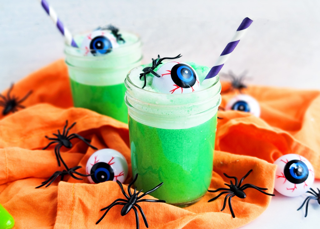 Try this Spooky Green Halloween Punch; green punch in a glass with plastic eyeballs and spiders and a purple straw littleeatsandthings.com