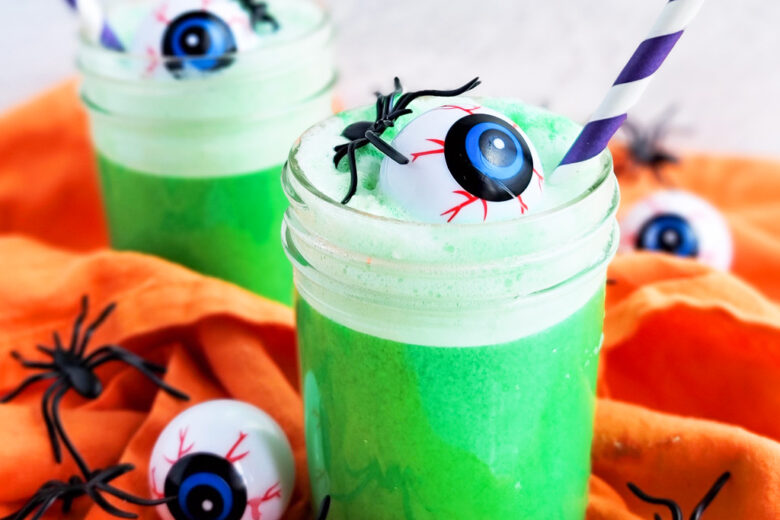 Try this Spooky Green Halloween Punch; green punch in a glass with plastic eyeballs and spiders and a purple straw littleeatsandthings.com