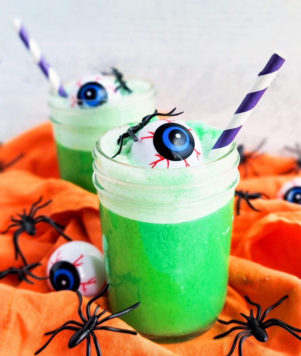 Try this Spooky Green Halloween Punch; green punch in a glass with plastic eyeballs and spiders and a purple straw littleeatsandthings.com