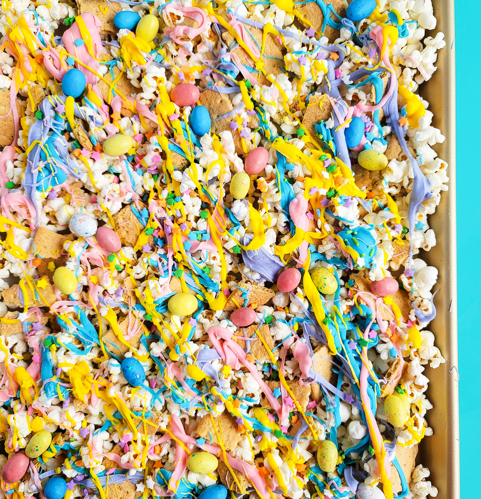 Easy Easter Popcorn with White Chocolate & Mini Eggs, purple, yellow, pink, and blue white chocolate beautifuleatsandthings.com