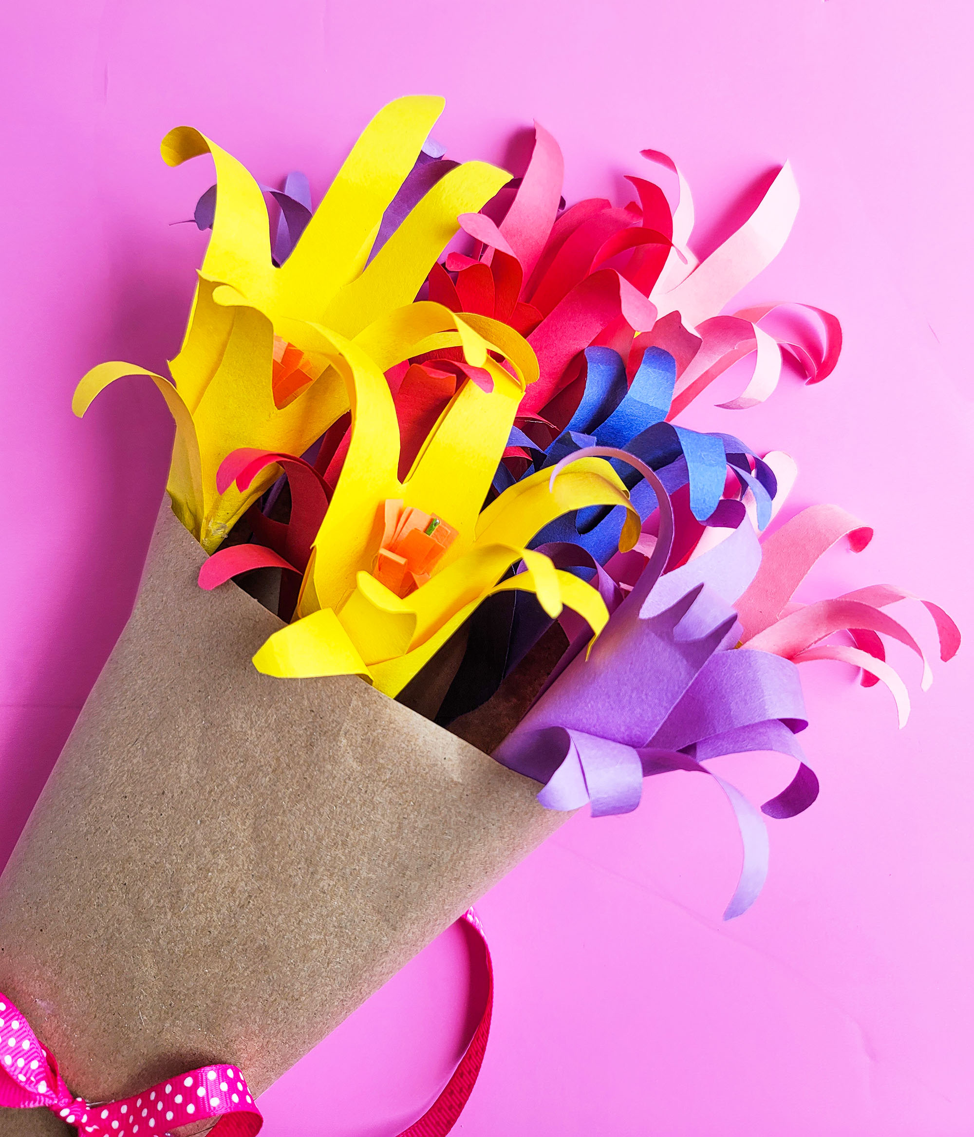 Easy DIY Handprint Flower Bouquet made from kids or students handprints on a pink surface  littleatsandthings.com