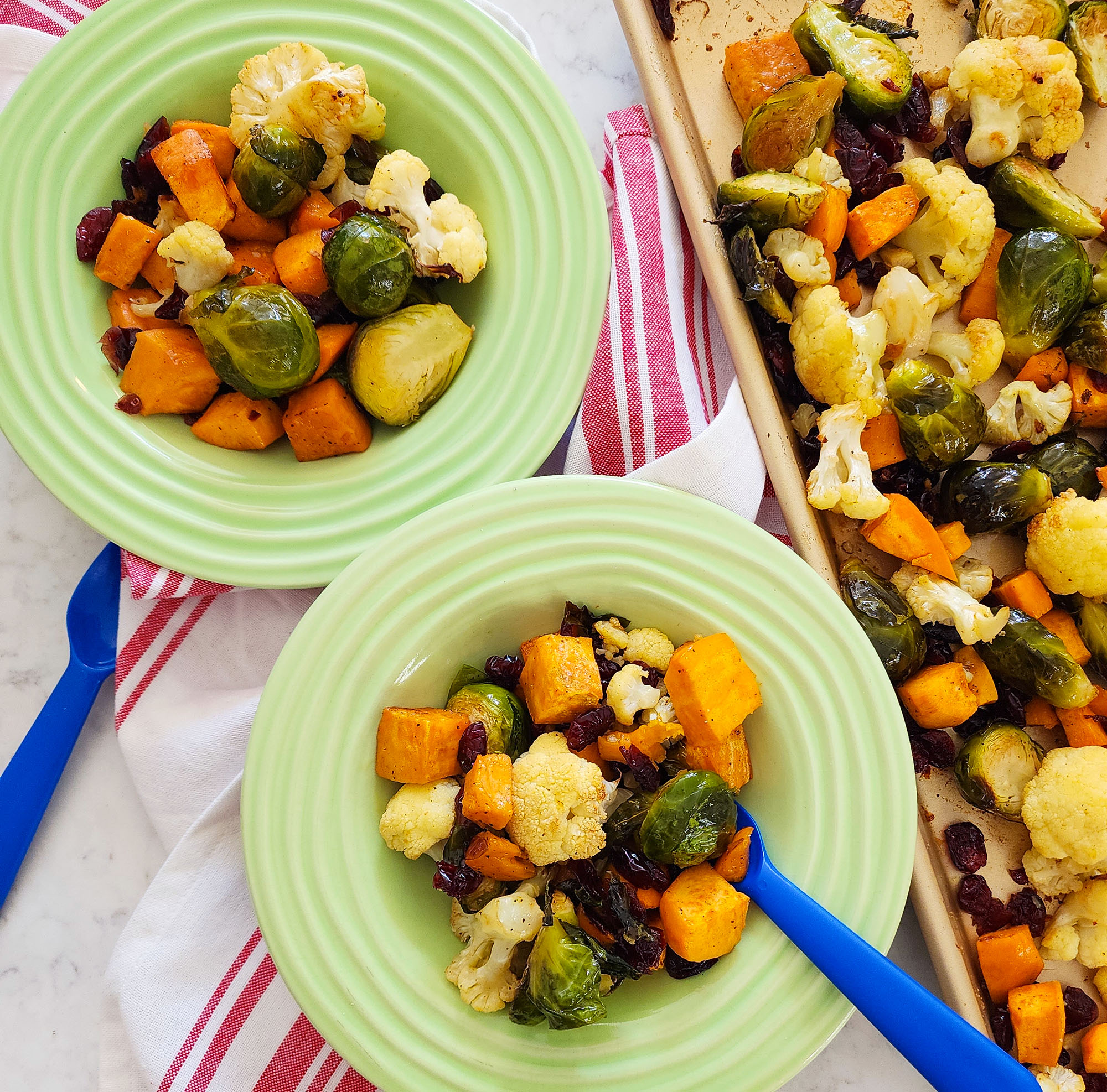 fall roasted vegetables, Brussels sprouts, sweet potatoes, cauliflower in on a baking sheet and green bowls  littleeatsandthings.com