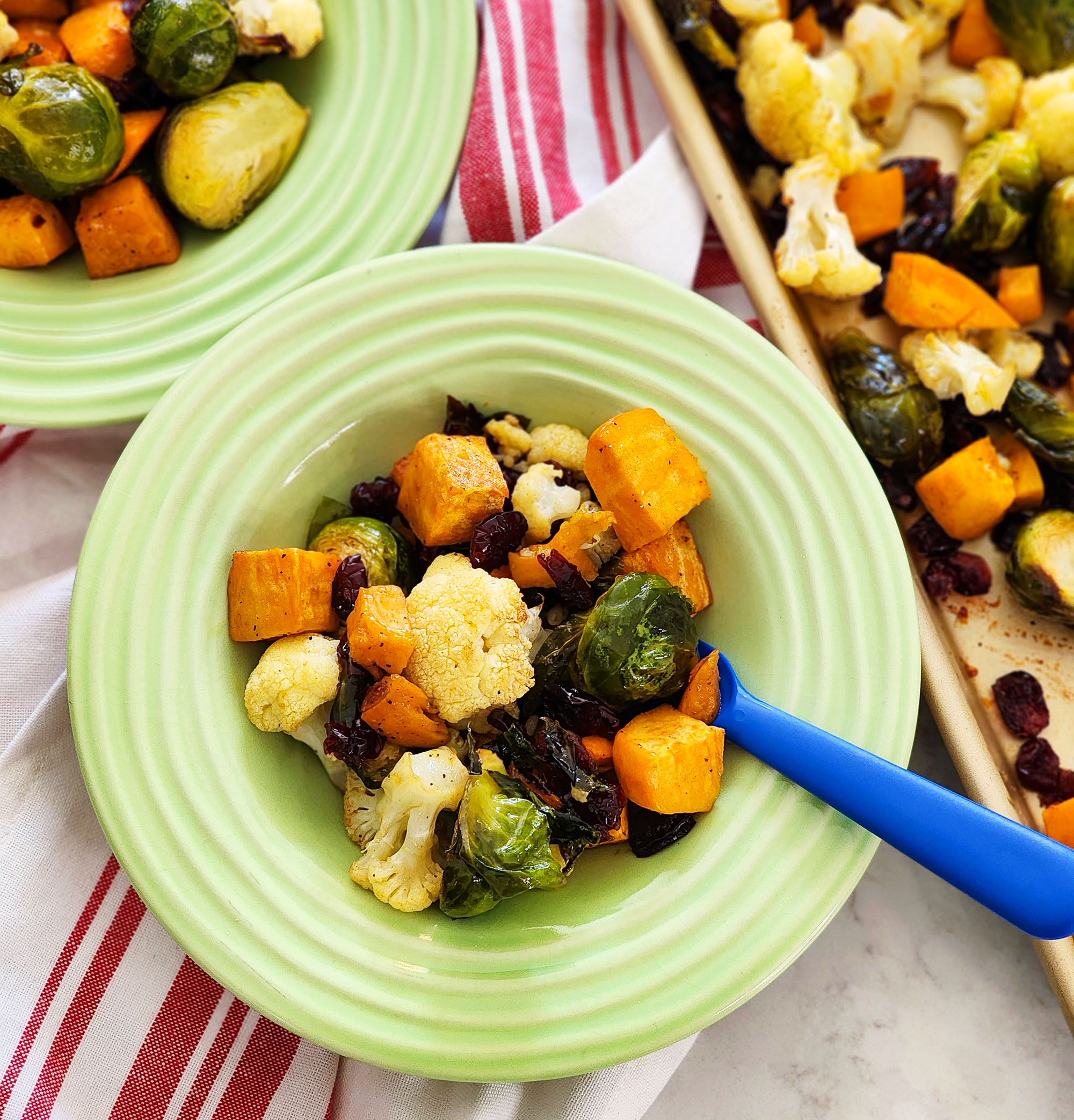 fall roasted vegetables, Brussels sprouts, sweet potatoes, cauliflower in on a baking sheet and green bowls  littleeatsandthings.com