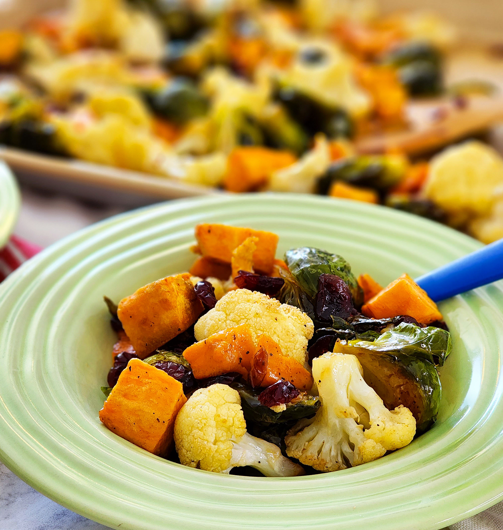 fall roasted vegetables, Brussels sprouts, sweet potatoes, cauliflower in on a baking sheet and green bowls  littleeatsandthings.com