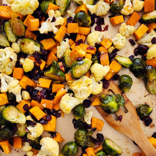 fall roasted vegetables, Brussels sprouts, sweet potatoes, cauliflower in on a baking sheet and green bowls littleeatsandthings.com