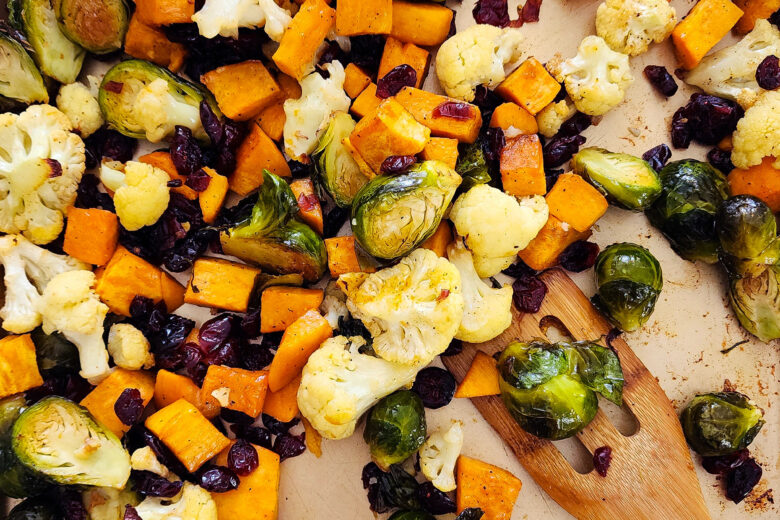 fall roasted vegetables, Brussels sprouts, sweet potatoes, cauliflower in on a baking sheet and green bowls littleeatsandthings.com